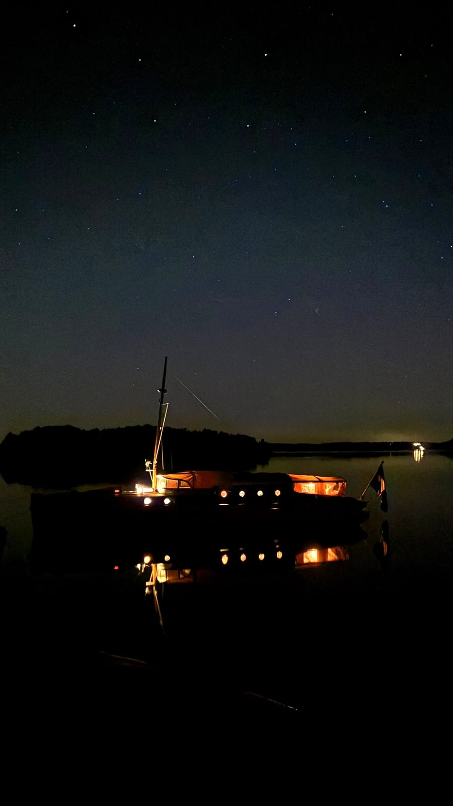 m/y IAN för ankar på natten med lysande kajutfönster